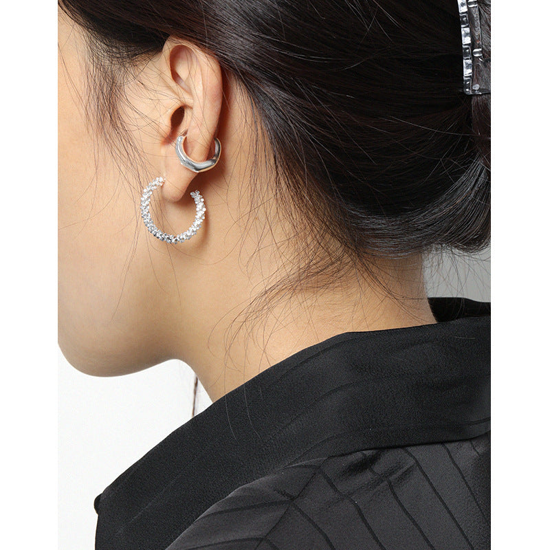 Unregelmäßiger Wellen-Clip-Ohrring aus 925 Sterling Silber von silverbene, modernes Design, einzelner Ohrring ansprechend fotografiert.